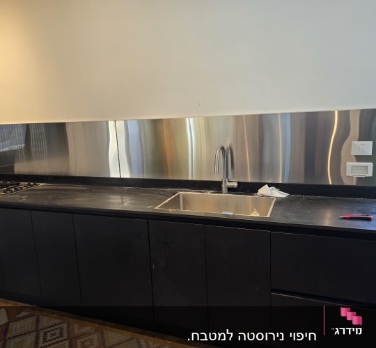 מטבח עם כיור וברז, משטח עבודה וכיריים